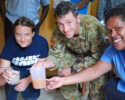 Project HOPE volunteer Rose Wilson and other participants of Pacific Partnership 2015 demonstrate the positive results of installing water purifiers at the clinics