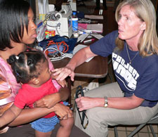 Project HOPE person examining child
