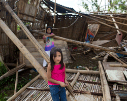 Two granddaughters of Elenita play in the wreckage of the home the family lived in together before Typhoon Haiyan