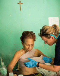 HOPE volunteer Carma Erickson-Hurt changes the bandage of cancer patient Elenita at Tapaz District Hospital