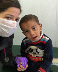 Dr. Corey Kahn with a young patient at the Gevgelija Transit Center, Macedonia
