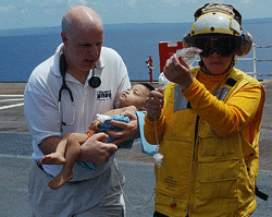 Dr. Dana Branner helps a child arriving on the USNS Mercy following the Indian Ocean Tsunami in 2005
