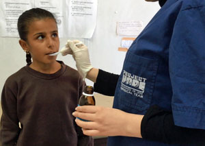Volunteer Dr. Angel Trposka provides medicine to a child along the Greek/Macedonia border.