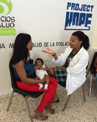 Dr. April Edwards with a patient and her mother at the Monte Plata women's and children's health clinic