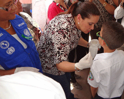 First Lady Ana Garcia Hernandez administers deworming medicine to a child