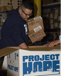 Jeremy Rosado helps Project HOPE staff pack $5 million-worth of medicines and supplies destined for the Philippines