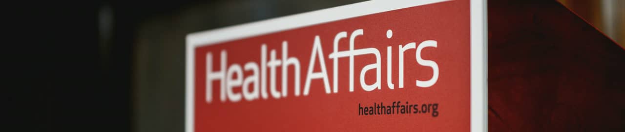 Podium with red Health Affairs sign in white type on a red background