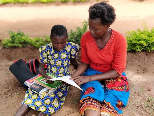 Mother teaching daughter in Malawi
