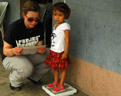 A young girl is helped by a Project HOPE volunteer
