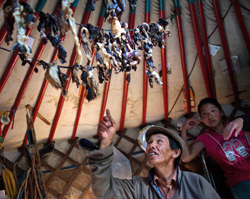 Baasanjav N., 57, explains the process for drying sheep meat, which he has hanging from the rafters of his traditional Mongolian ger home, as he visits with Project HOPE volunteers near where operation Pacific Angel Mongolia has set up camp in Eastern Mongolia, July 23, 2011.