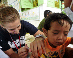 A Project HOPE volunteer nurse inoculates a young Philippino boy during Pacific Partnership 2012