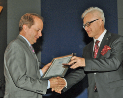 Dr. Tom Kenyon receives the award from Dr. Krzysztof Fyderek, Medical Director of UCH