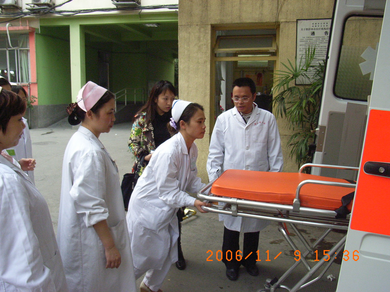 Medical students loading empty stretcher into ambulance