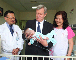 US Ambassador to China Max Baucus visits with one of the pediatric heart patients at the Shanghai Children Medical Center in 2014