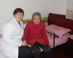 Volunteer Linda Rice, RN with a 96-year-old nursing home resident in Wuhan, China