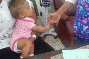 Baby in Dominican Republic reaches out to medical worker