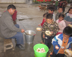 Teacher in rural China serving breakfast to students. 