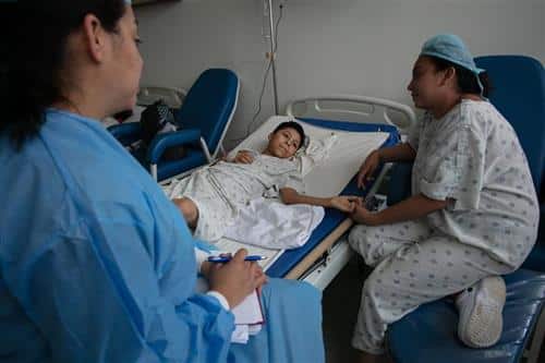Burn patient holding his mothers hand