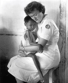 black and white photo of nurse holding child