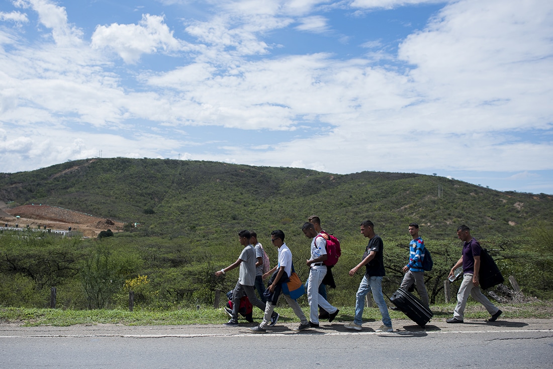 Venezuelans walk along a road in the countryside