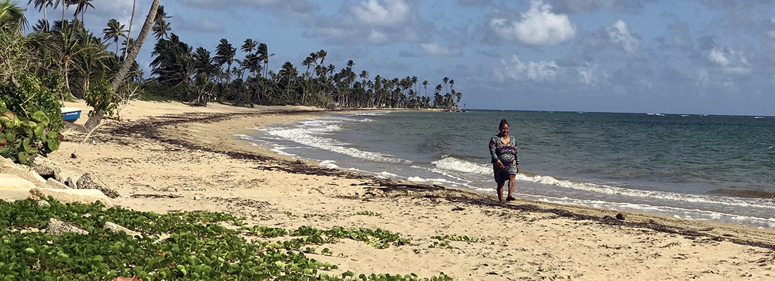 Woman walking along the beach in Loiza, Puerto Rico. 