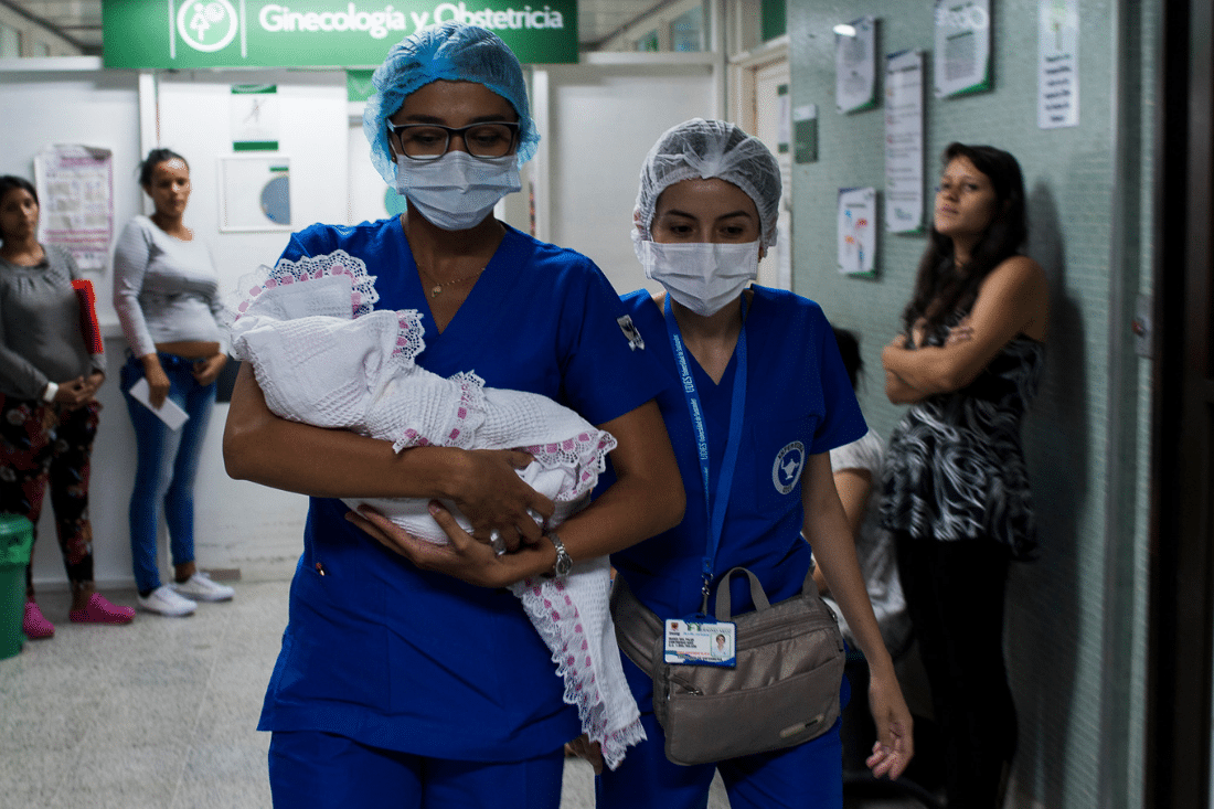 Nurses carry a baby at a hospital in Colombia