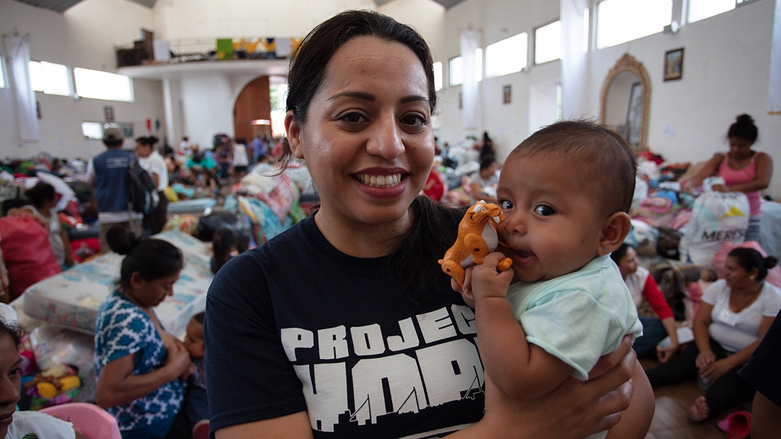 Volunteer holding a baby. 