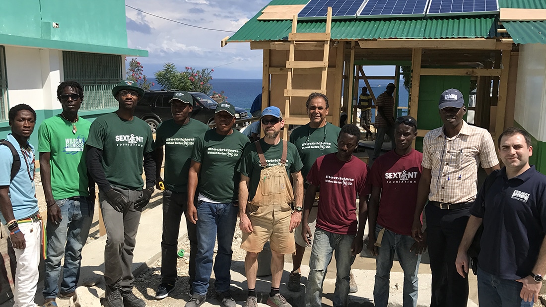 volunteer team in front of a treatment center that is being built. 
