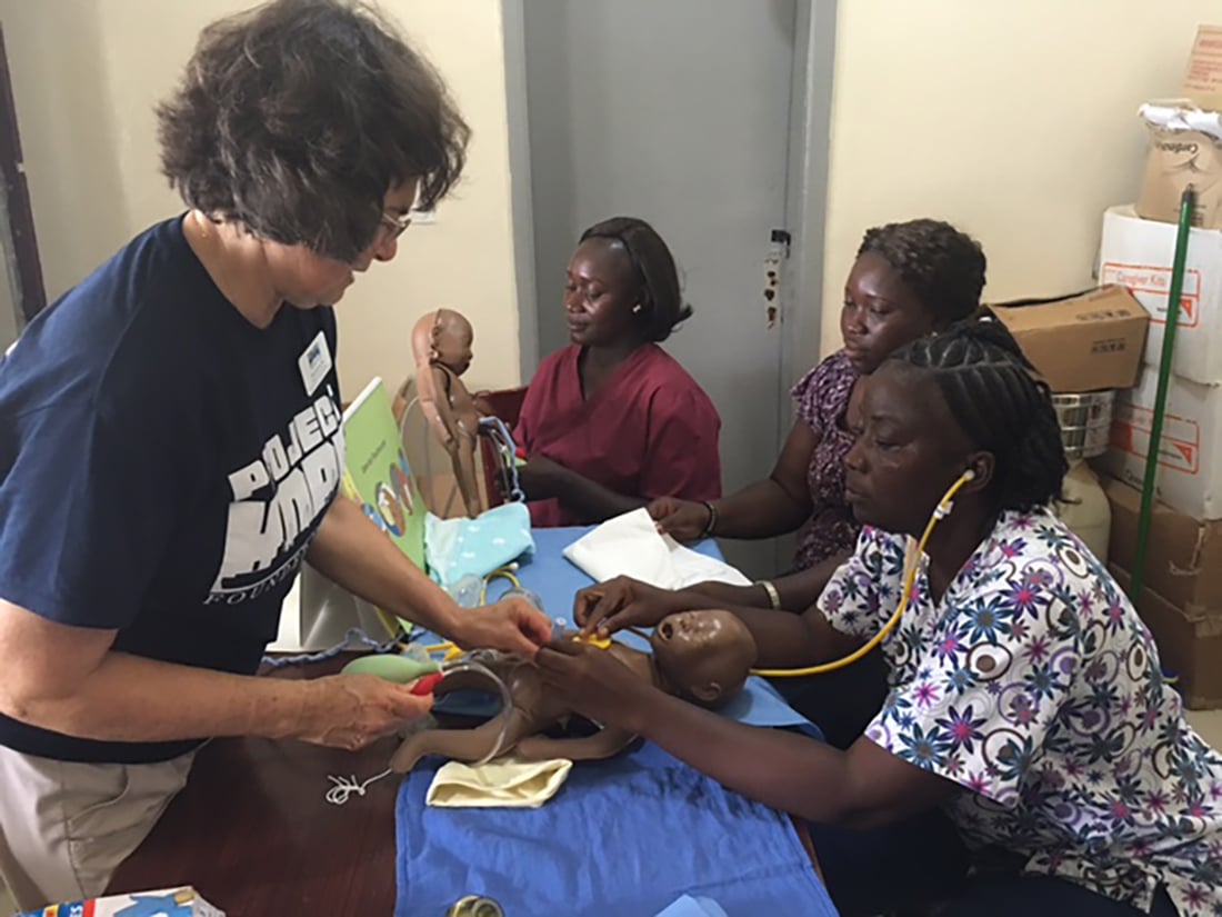 medical volunteer training local health care worker in essential newborn care in Sierra Leone. 