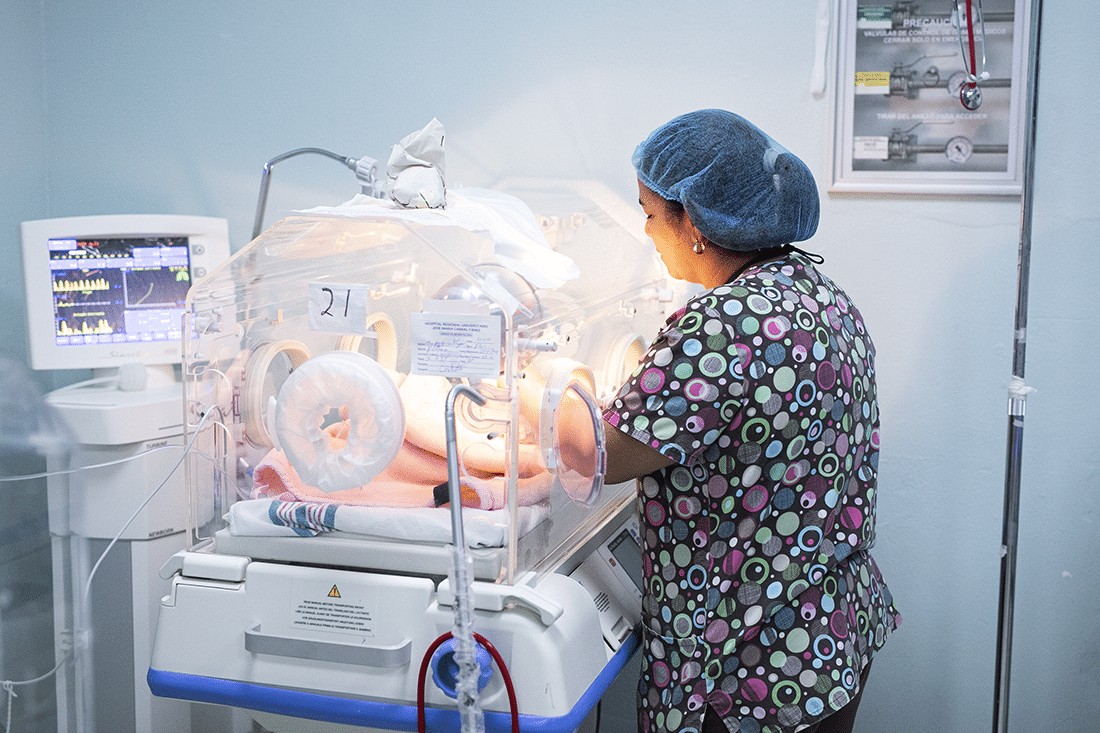 Nurse treating a baby in an incubator