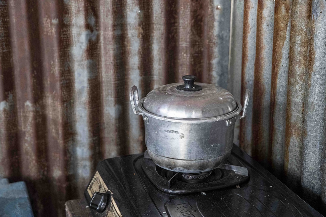 A silver pot with lid sitting on stove