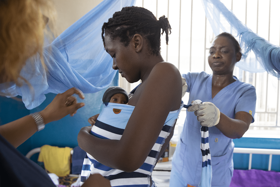 Small baby being wrapped to its mother with skin-to-skin contact in Sierra Leone.