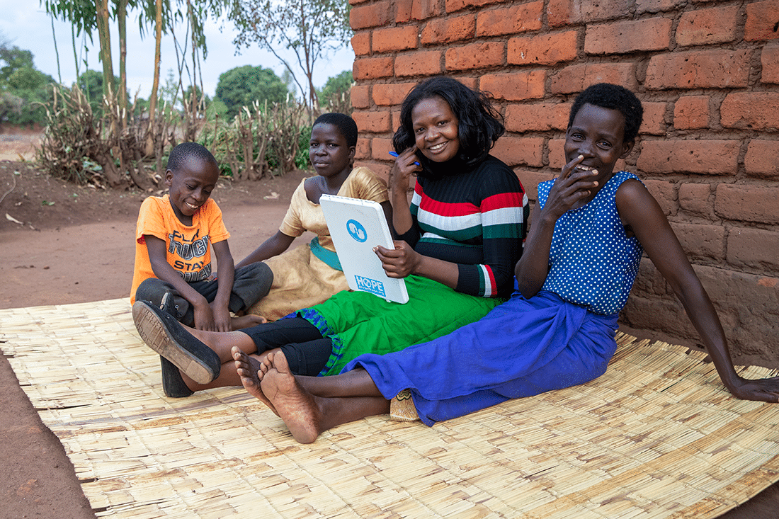 Project HOPE community engagement facilitator Ellina talks to beneficiaries in a village in Malawi.
