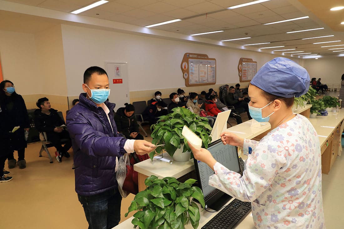 Patient checks in at a hospital with face mask on.