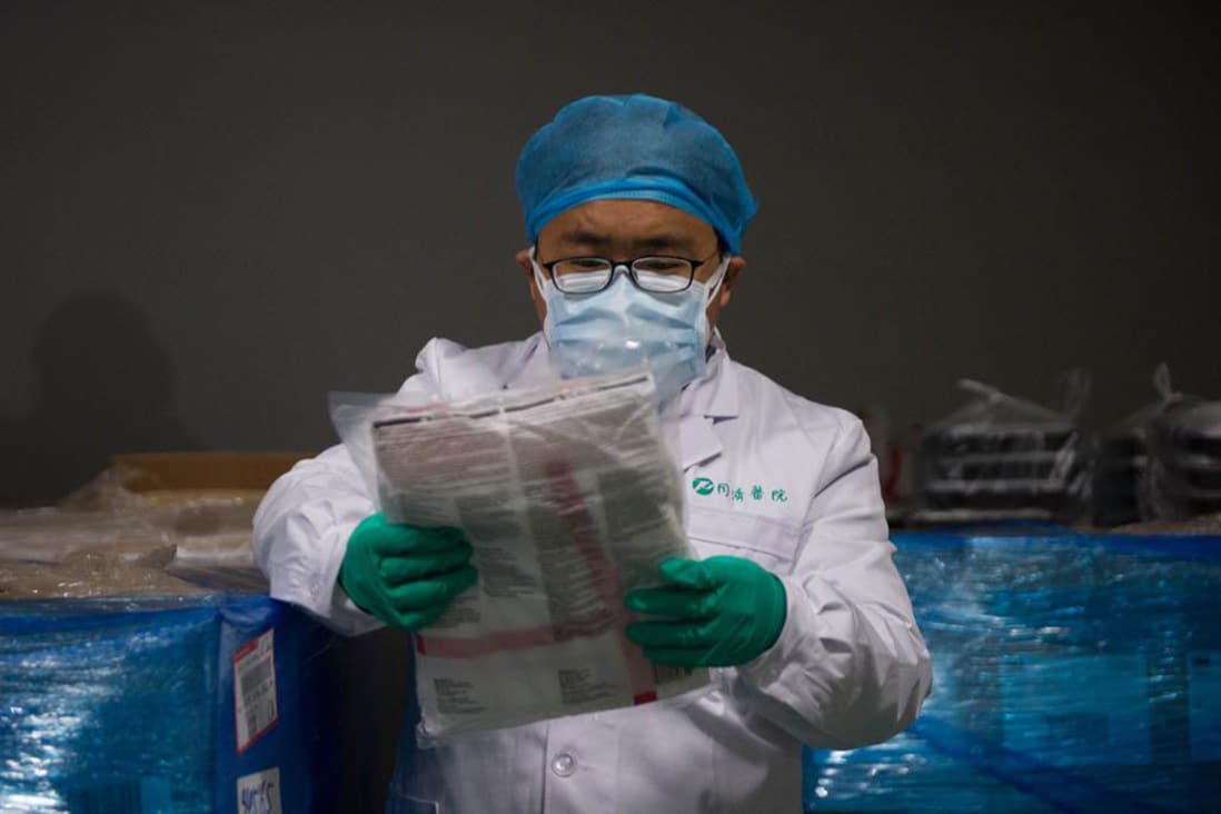 Doctor wearing protective gear inspects a package.