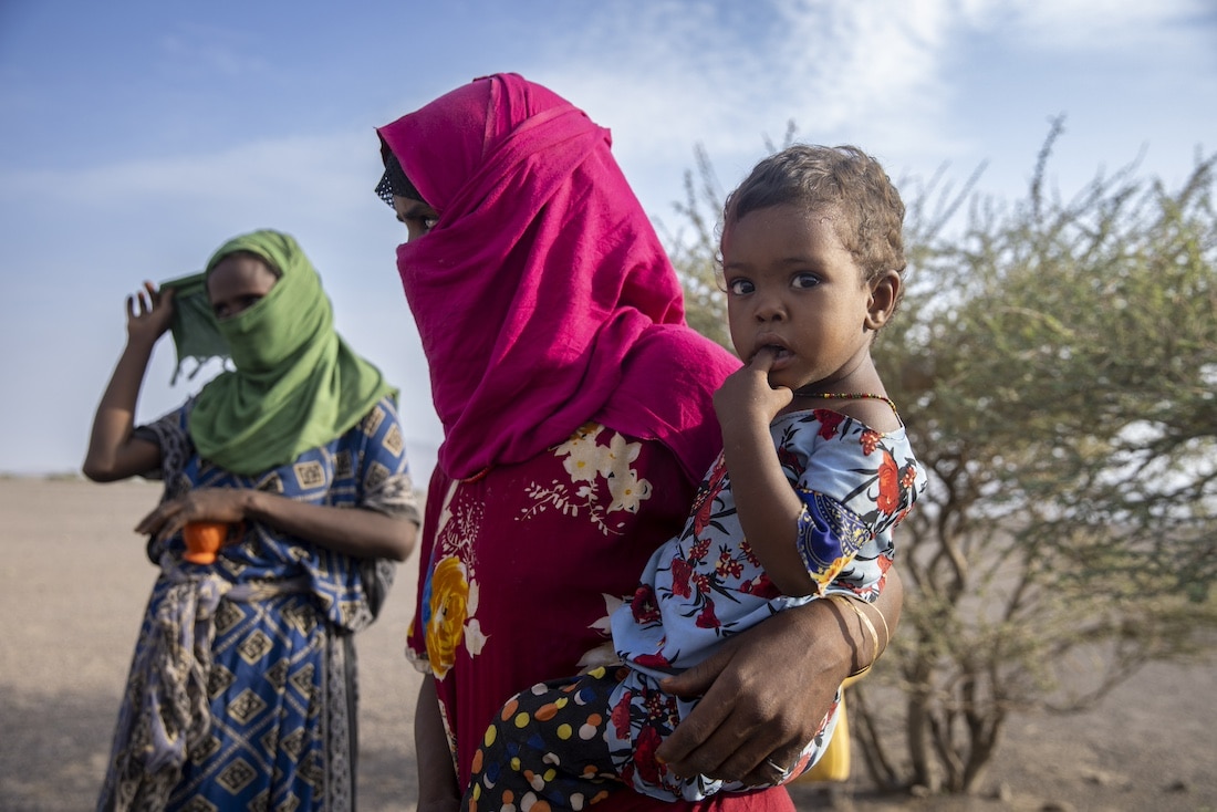 woman holding child in desert