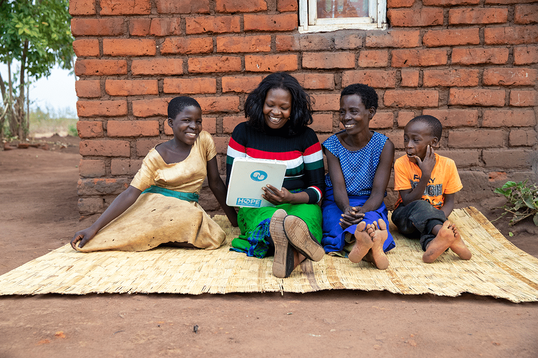 Ellina and Rose's family outside her home in Malawi