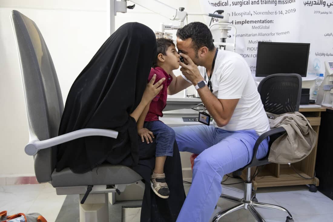 Doctor in Yemen performing eye exam on child
