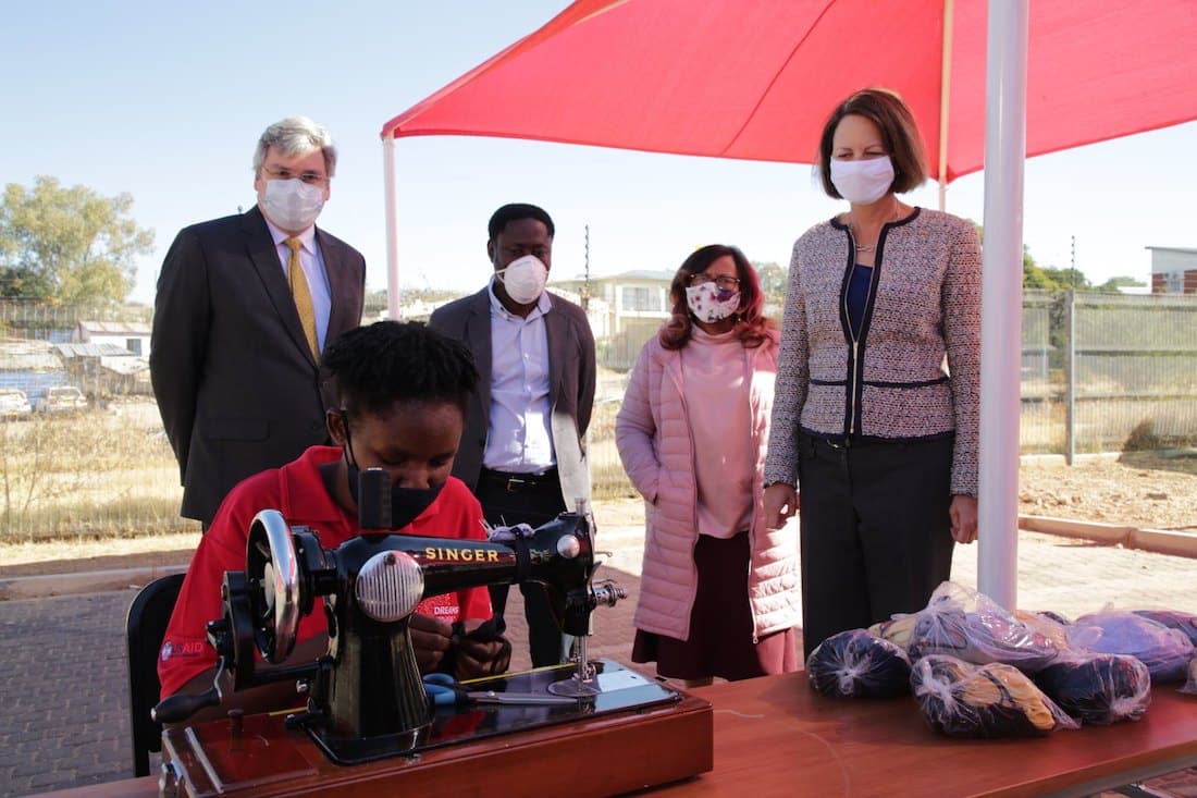 US Ambassador Lisa Johnson watches DREAM member sewing a mask in Namibia