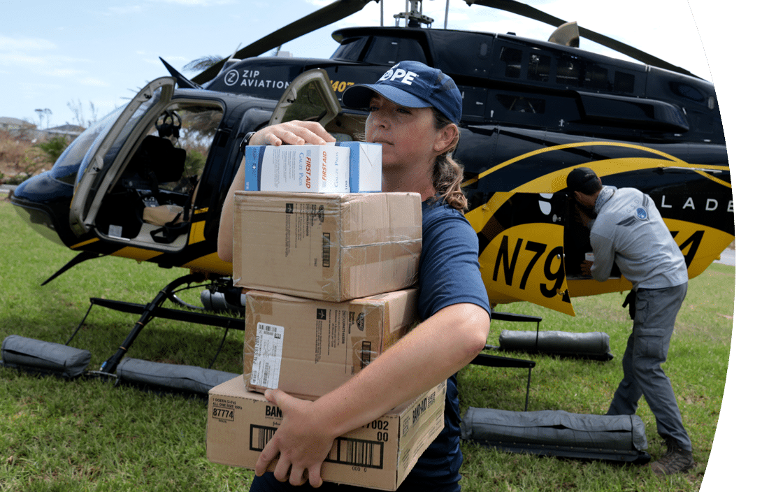 Project HOPE team member unloading supplies from a helicopter