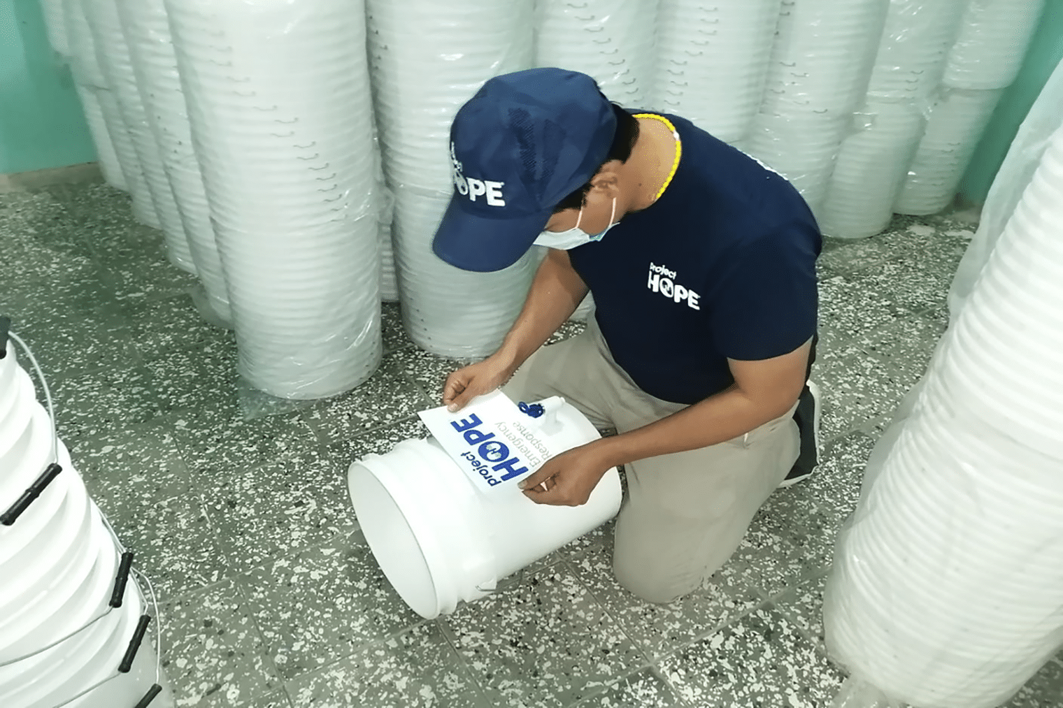 worker making water filtration out of buckets