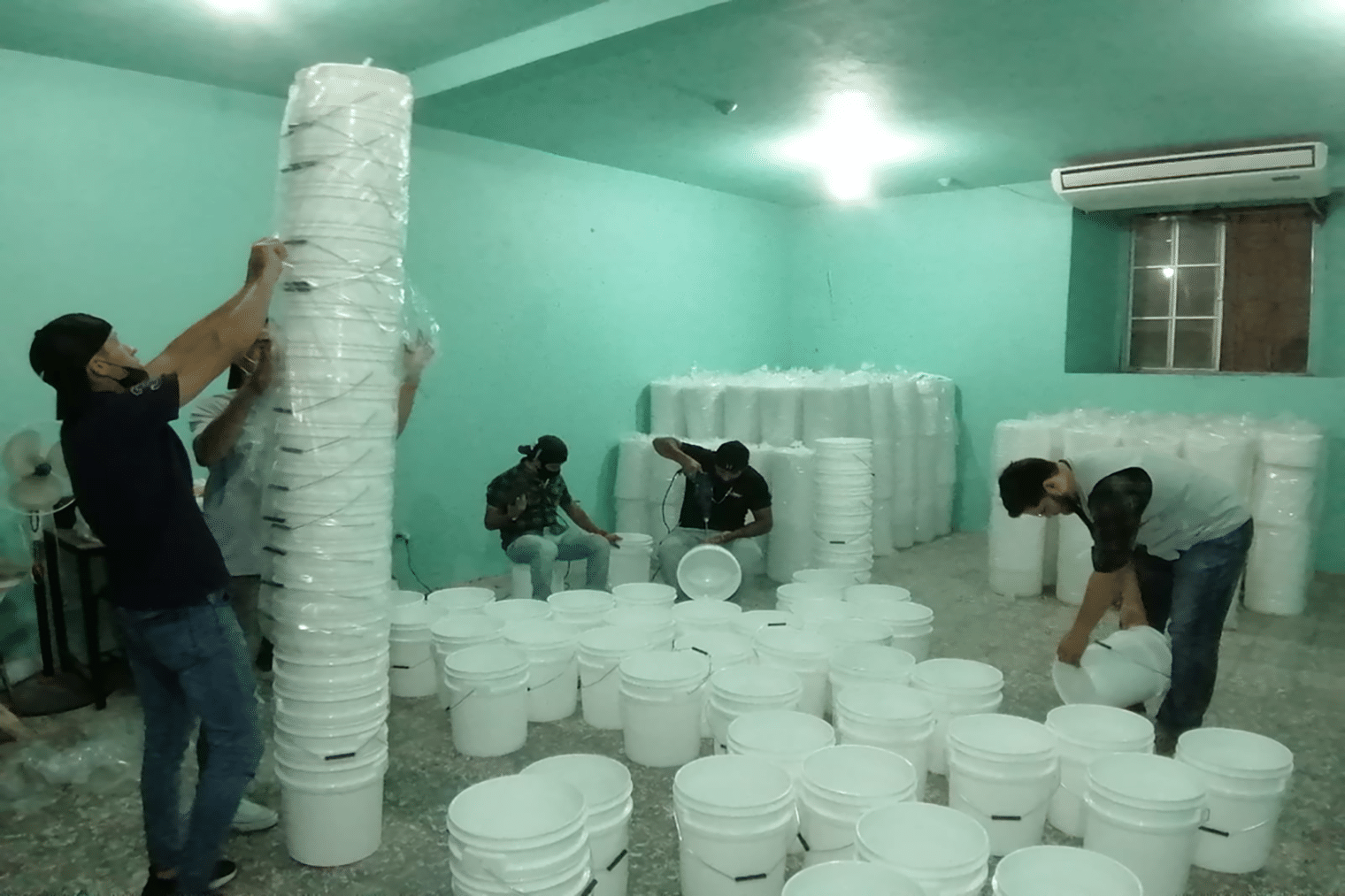 workers preparing water filtration out of buckets