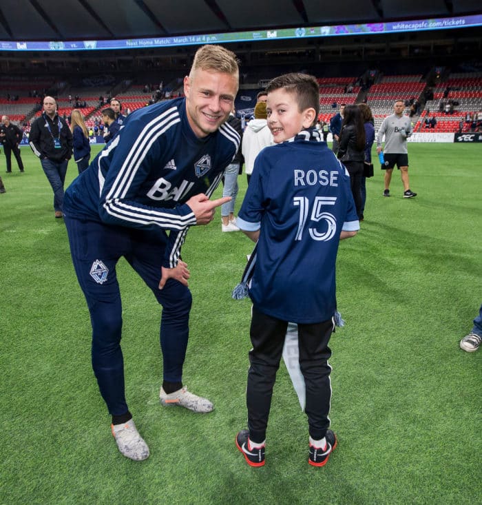Vancouver Whitecaps' Andy Rose poses with a young fan