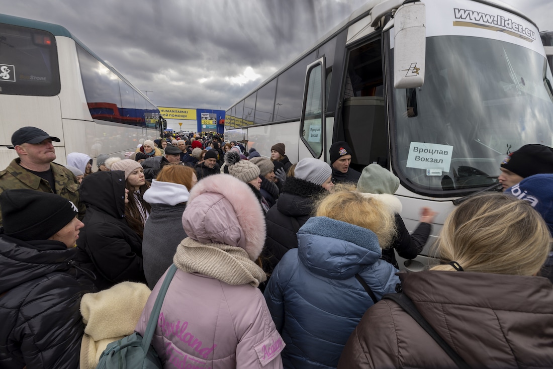 Refugees board a bus in Poland