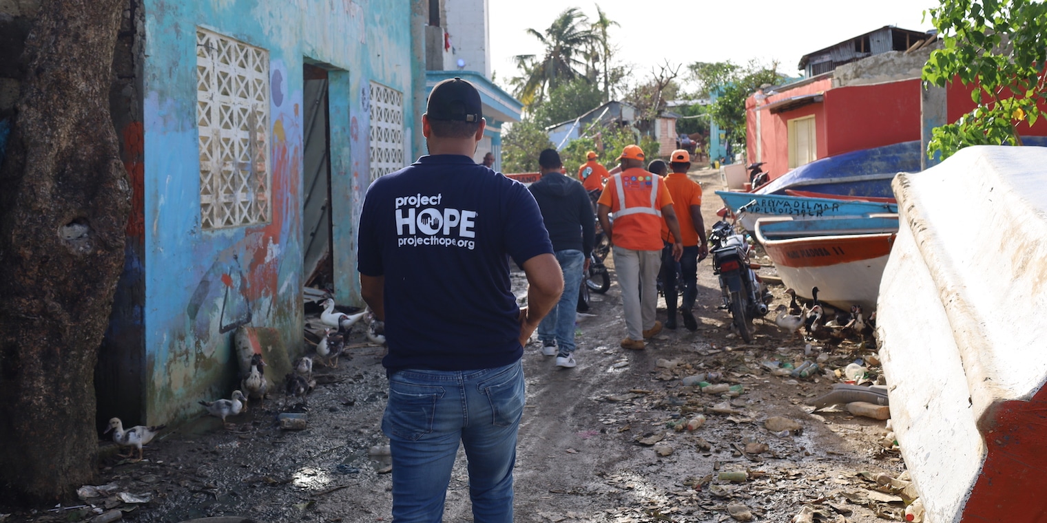 staff members walking through wreckage in Dominican Republic