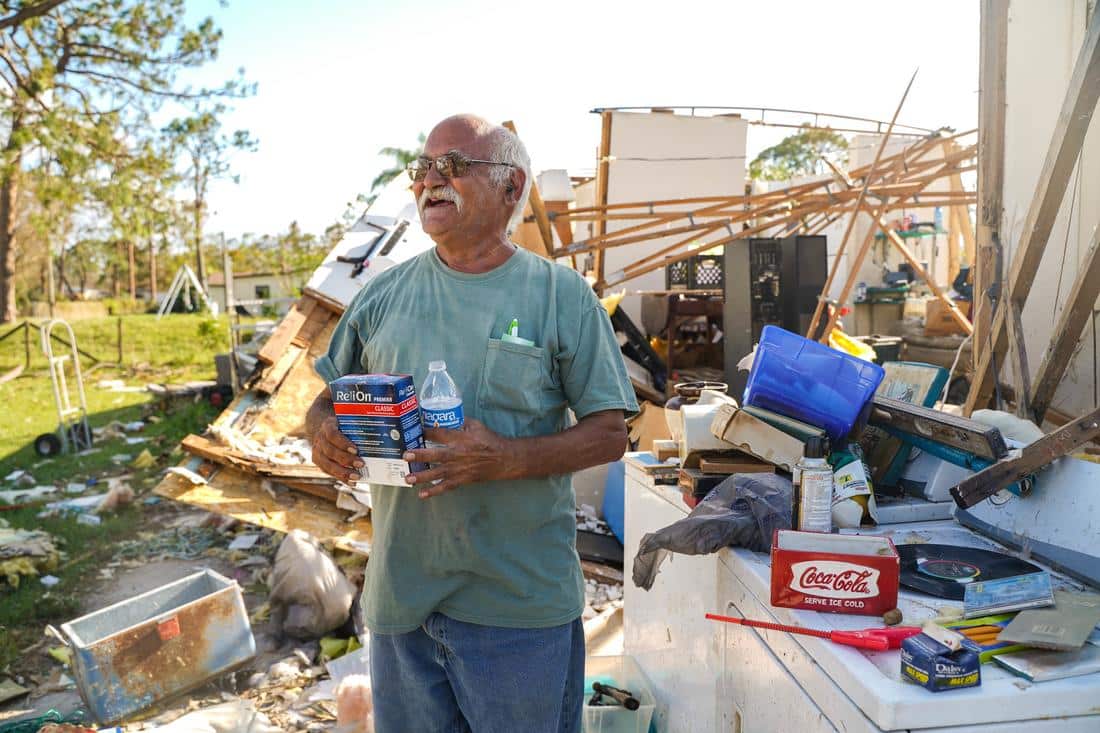 man standing in front of destroyed home