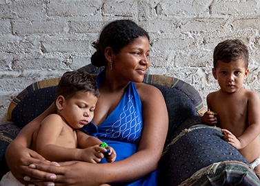 Carina (seated) is a Venezuelan migrant in Colombia, shown here with her two young twin boys. Seven months pregnant, Carina is a participant at a maternal health workshop held by Corporación Mujer Denuncia y Muévete (CMDYM), a female-led organization Project HOPE supports in Colombia.