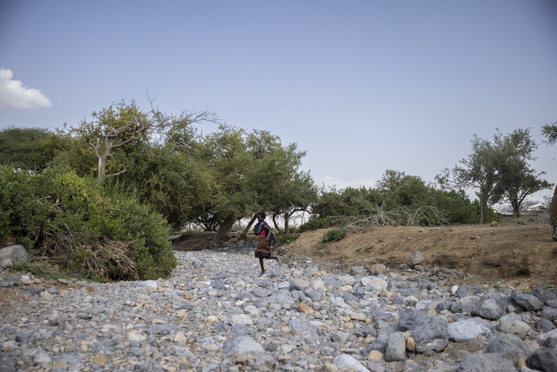 woman walking in dry riverbed in Ethiopia