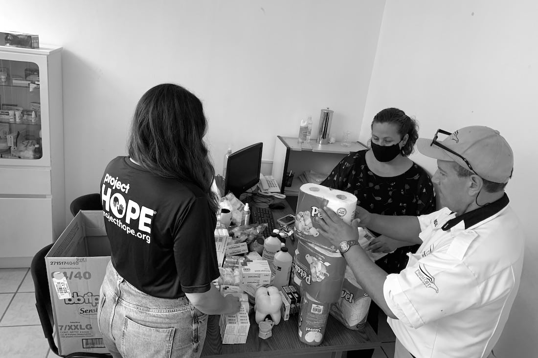 black and white image of Project HOPE staff speaking with people