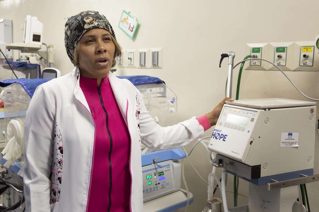 A nurse speaking next to an incubator machine